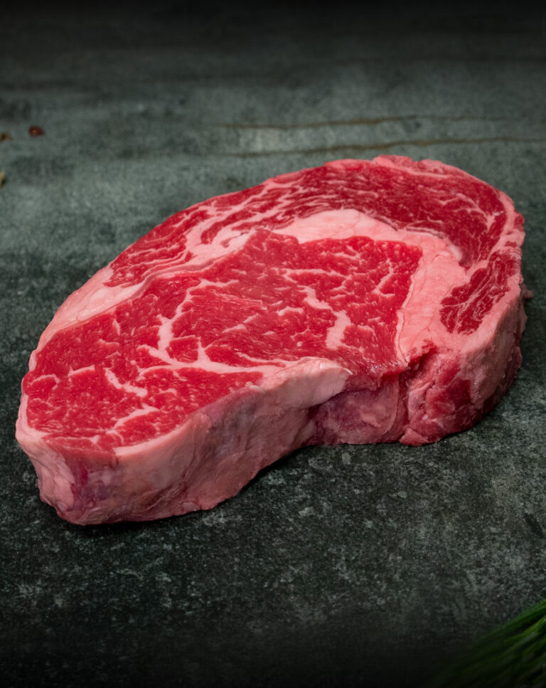 Marmoriertes US Ribeye Steak von Creekstone Farms, präsentiert auf einer Schieferplatte für Gezer Gastro-Kunden.