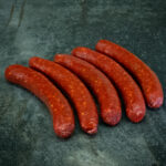 Würzige regionale Merguez auf einer schwarzen Schieferplatte für Gezer Gastro-Kunden.