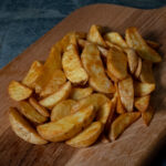 Potato Wedges mit Schale, goldbraun auf einer Schieferplatte präsentiert für Gezer Kunden.
