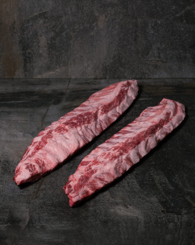 Rohe Spareribs vom Ibérico-Schwein, mit feiner Fettmarmorierung auf einer Schieferplatte präsentiert für Gezer Kunden.