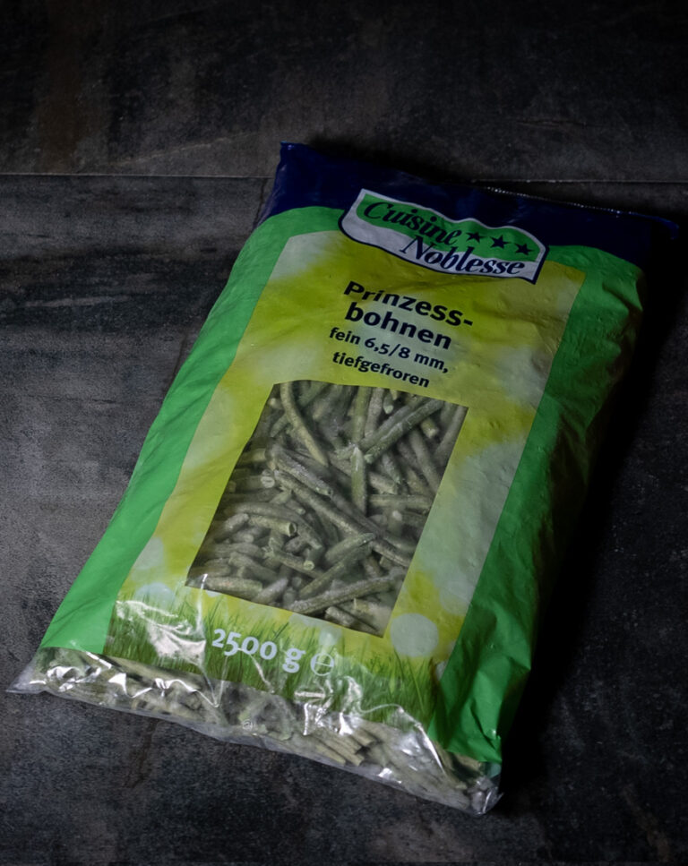 Knackfrische, extra feine Prinzessbohnen in einer Verpackung, ideal als Beilage pariert. Auf einer Schieferplatte für Gezer Gastronomie-Kunden präsentiert.