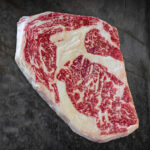 Rohes, stark marmoriertes Wagyu Ribeye Tajima BMS 7-9 aus Australien mit markantem Fettkern. Präsentiert für Gezer Gastronomie-Kunden.