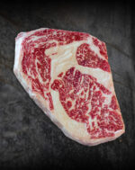 Rohes, stark marmoriertes Wagyu Ribeye Tajima BMS 7-9 aus Australien mit markantem Fettkern. Präsentiert für Gezer Gastronomie-Kunden.