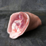 Rohe Duroc Schweinshaxe auf einer dunklen Schieferplatte präsentiert für Gezer Gastro-Kunden.