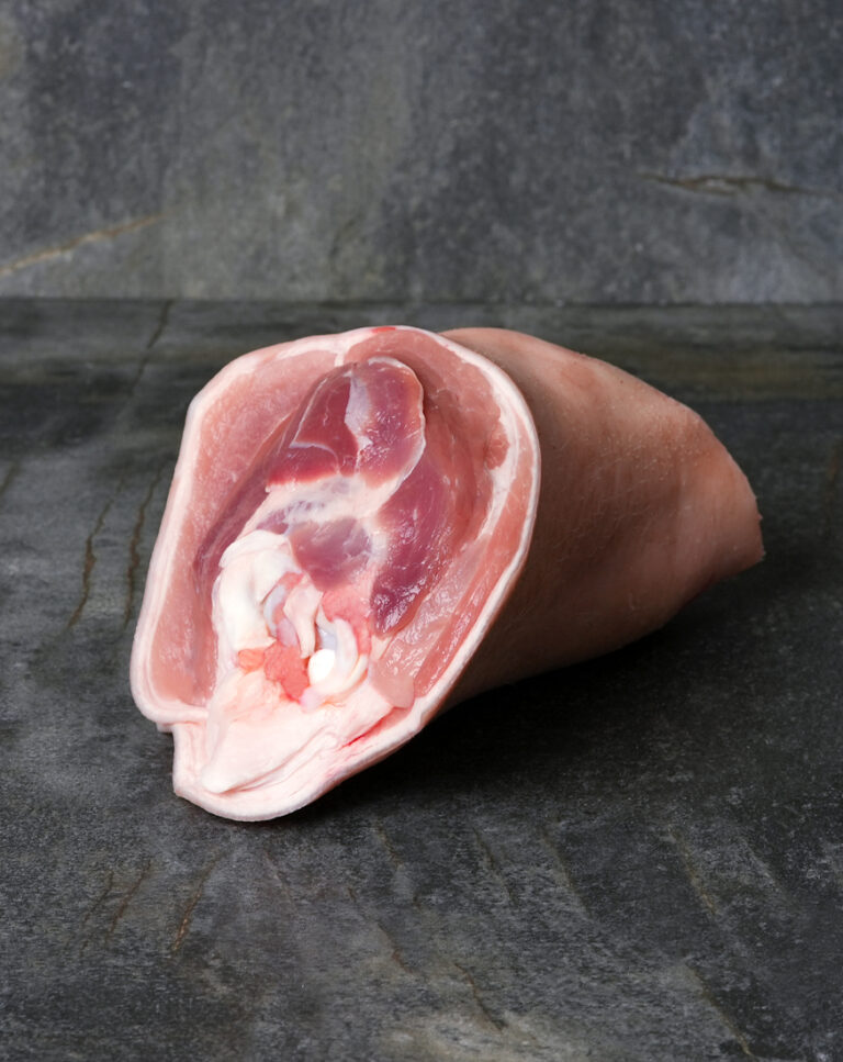 Rohe Duroc Schweinshaxe auf einer dunklen Schieferplatte präsentiert für Gezer Gastro-Kunden.