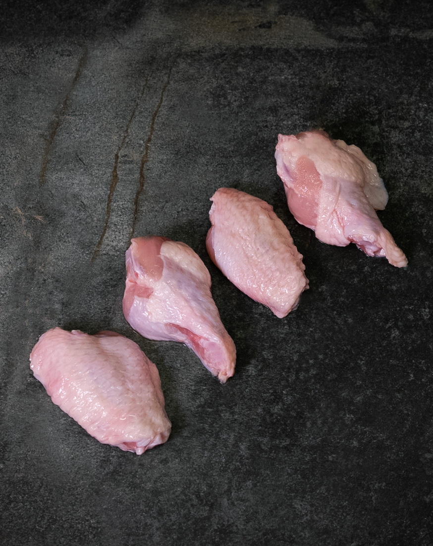 Chicken Wings, appetitlich angerichtet auf einer Schieferplatte für Gezer Gastronomie-Kunden.
